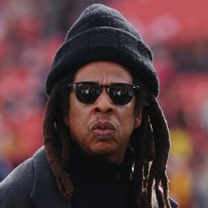 Rapper Jay-Z (C) looks on before a game between the Washington Commanders and the Dallas Cowboys at Northwest Stadium on November 24, 2024 in Landover, Maryland.