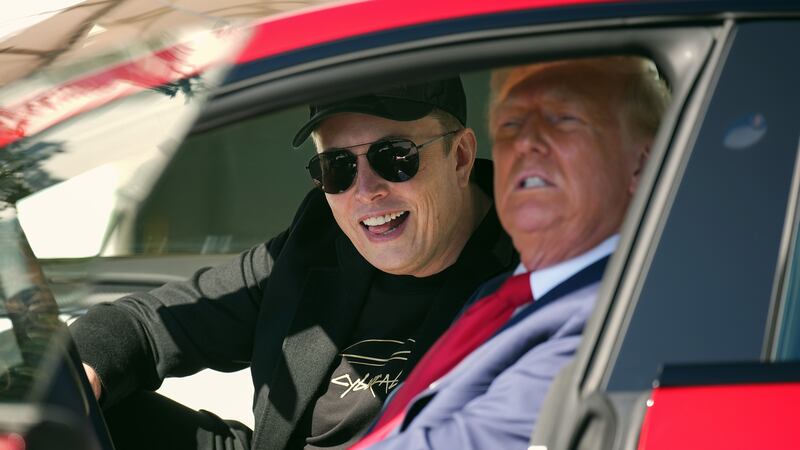 Elon Musk and Trump sit in a Tesla.