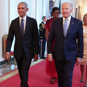 Barack Obama and Joe Biden walk down the hall in the White House in 2022.