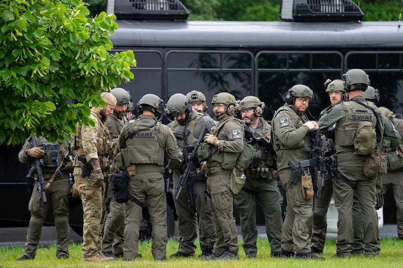 Law enforcement officers including local police, sheriffs and the FBI, stage less than a mile from a shooting in Brooklyn Park, Minn. on Saturday, June 14, 2025. (Alex Kormann/Star Tribune via AP)