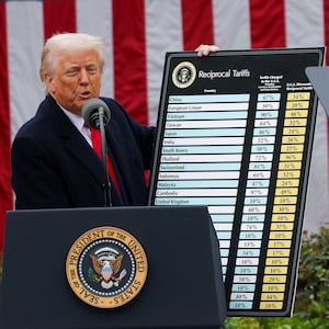 President Donald Trump holds a placard revealing his tariff plans in the Rose Garden at the White House.