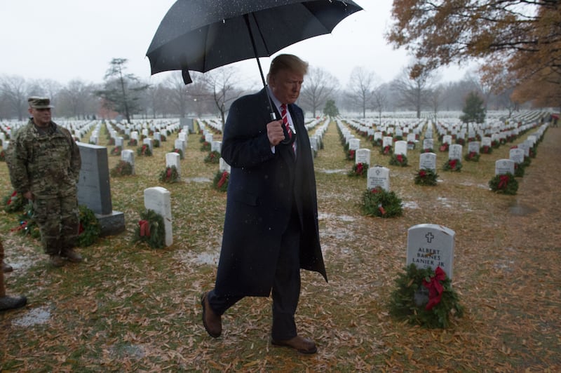 TOPSHOT - US President Donald Trump walks past tombstones during an unscheduled visit to Arlington National Cemetery on December 15, 2018 in Arlington, Virginia.
