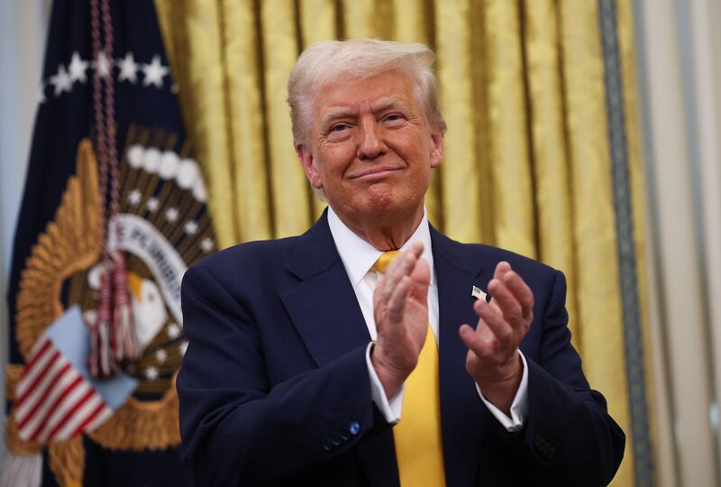 U.S. President Donald Trump applauds after Howard Lutnick was sworn in as U.S. Commerce Secretary in the Oval Office at the White House on February 21, 2025 in Washington, DC.