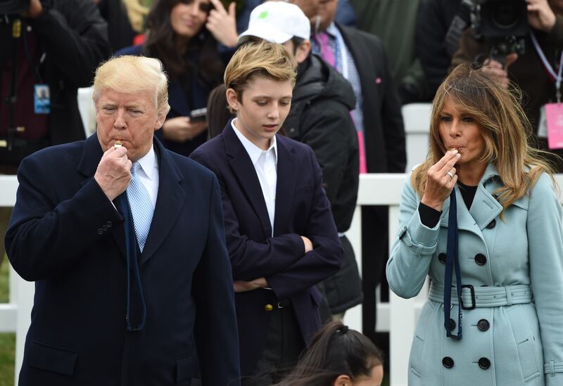 President Donald Trump and First Lady Melania Trump, with son Barron, blow whistles at the start of an Easter egg roll during Easter celebrations at the White House in 2018.