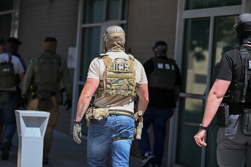 Masked law enforcement officers, including HSI and ICE agents, walk into an immigration court in Phoenix, Arizona, in May—agents have been covering their faces with masks during law enforcement operations.