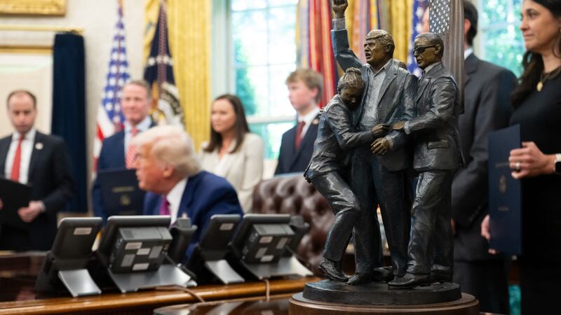 TOPSHOT - A statue depicting the attempted assassination of US President Donald Trump in Butler, Pennsylvania, sits alongside the Resolute Desk as Trump signs legislation relating to household consumer energy policies in the Oval Office of the White House in Washington, DC, on May 9, 2025. (Photo by SAUL LOEB / AFP) (Photo by SAUL LOEB/AFP via Getty Images)