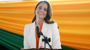 Kate Middleton smiles while giving remarks at a podium.