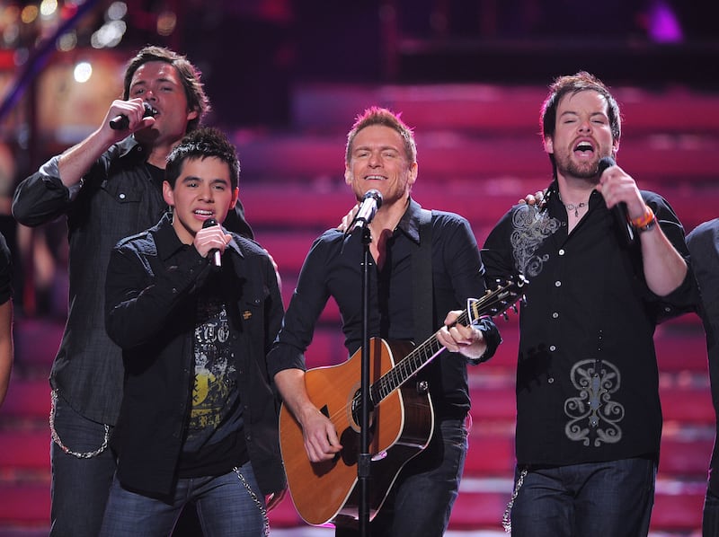 David Archuleta and David Cook perform on stage with musician Bryan Adams at the American Idol Season 7 Grand Finale.
