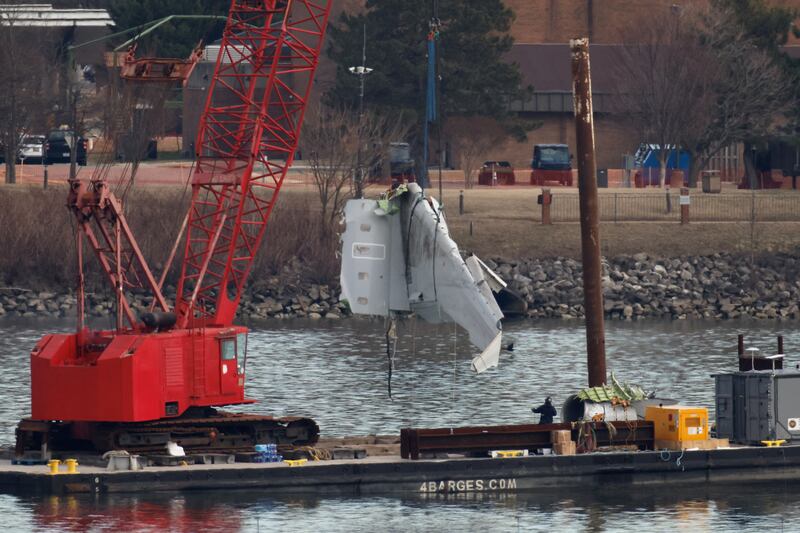 A crane retrieves a wing from the wreckage in the Potomac River, in the aftermath of the collision of American Eagle flight 5342 and a Black Hawk helicopter that crashed into the river, by the Ronald Reagan Washington National Airport, in Arlington, Virginia, U.S., February 3, 2025.