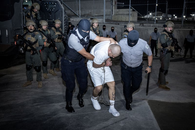 Police officers escort an alleged member of the Venezuelan gang Tren de Aragua, recently deported by the U.S. government, to be imprisoned in the Terrorism Confinement Center prison in Tecoluca, El Salvador, in this handout image obtained March 16, 2025.
