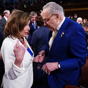 Senate Minority Leader Chuck Schumer  chats with former House Speaker Nancy Pelosi on the House floor.