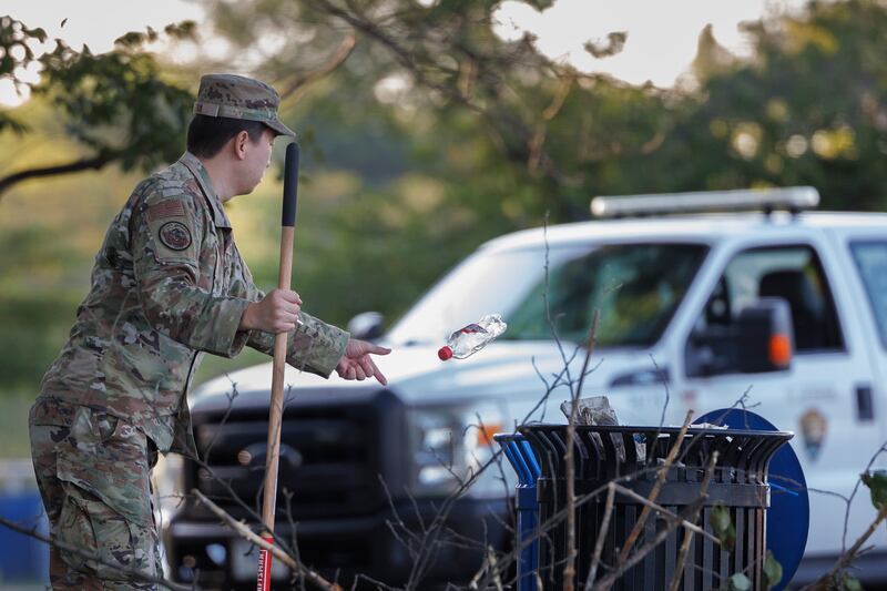 A National Guard troop discarding a bottle  near the National Mall—tasks typically falling to the National Park Service are being picked up by the Guard after Trump slashed the federal workforce.