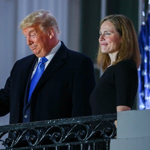 U.S. President Donald Trump gestures as he poses with U.S. Supreme Court Associate Justice Amy Coney Barrett on a White House balcony after she was sworn in to serve as an associate justice of the U.S. Supreme Court at the White House in Washington, U.S., October 26, 2020.   REUTERS/Tom Brenner