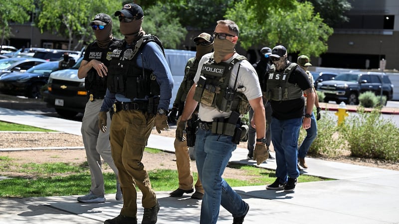Masked law enforcement officers, including HSI and ICE agents, walk into an immigration court in Phoenix, Arizona, U.S., May 21, 2025.