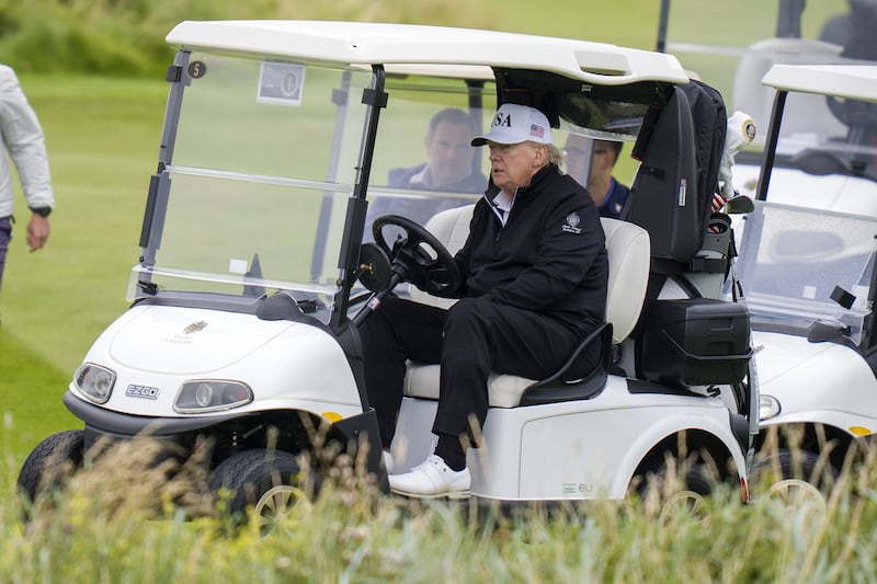 President Donald Trump steers a regular golf cart at his Trump Turnberry golf course.