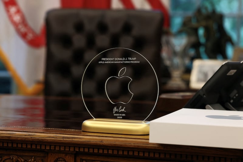 A gift given by Apple CEO Tim Cook to U.S. President Donald Trump stands on President Trump's table, as they present Apple's announcement of a $100 billion investment in U.S. manufacturing, in the Oval Office at the White House in Washington, D.C., U.S., August 6, 2025. REUTERS/Jonathan Ernst