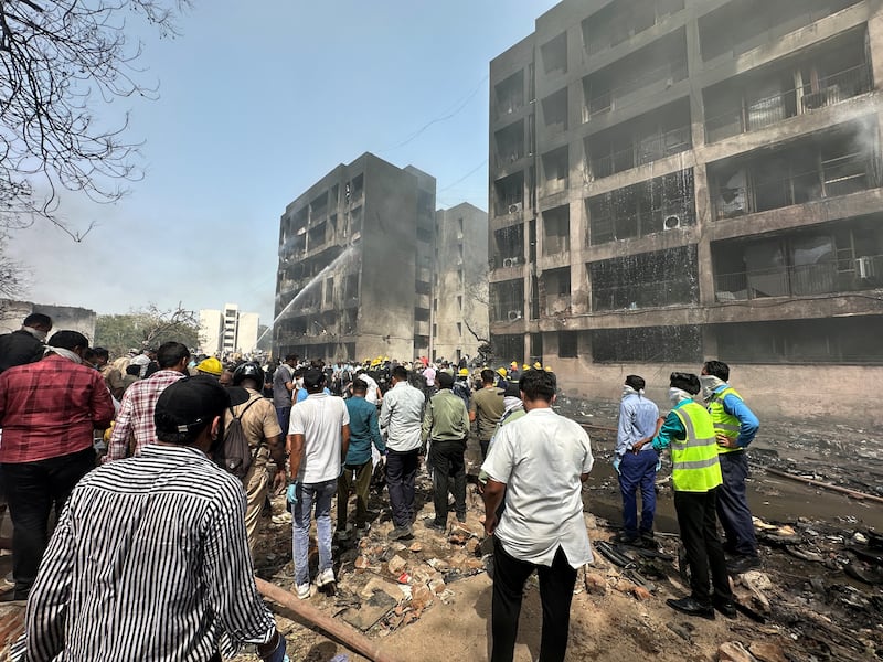 People gather near the site where an Air India plane crashed in Ahmedabad, India, June 12, 2025.
