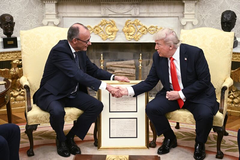 US President Donald Trump and German Chancellor Friedrich Merz (L) shake hands during a bilateral meeting in the Oval Office of the White House