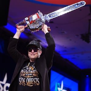 Elon Musk leaves the stage holding a chainsaw after speaking at the Conservative Political Action Conference (CPAC).