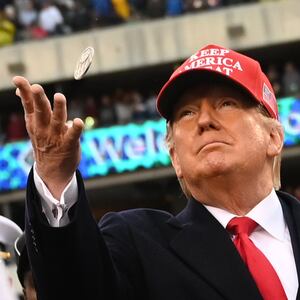 President Trump tosses a coin in a football stadium