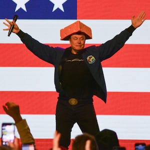 TOPSHOT - Elon Musk wears a Cheesehead hat as he speaks during a town hall in Green Bay, Wisconsin on March 30, 2025. An election to choose a new supreme court judge in the northern US state of Wisconsin wouldn't usually make much noise.
