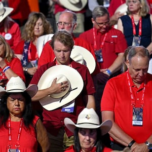 Delegates stand in prayer during the first day of the 2024 Republican National Convention.