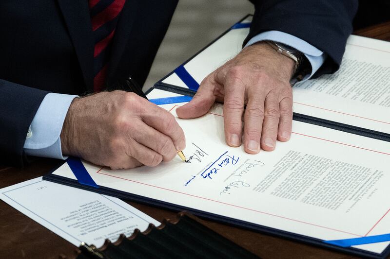 US President Joe Biden signs a resolution to avert a nationwide rail shutdown, in the Roosevelt Room of the White House in Washington, DC, on December 2, 2022. - Biden signed into law Friday a rare intervention by Congress forcing freight rail unions to accept a salary deal, avoiding a possibly devastating strike. (Photo by Brendan Smialowski / AFP) (Photo by BRENDAN SMIALOWSKI/AFP via Getty Images)
