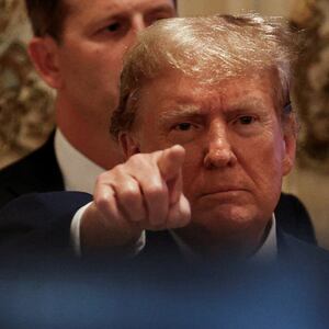 Donald Trump points at a camera at a campaign event.