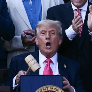 US President Donald Trump (C) holds a gavel after signing the "Big Beautiful Bill Act" at the White House in Washington, DC, on July 4, 2025. US President Donald Trump signed his flagship tax and spending bill on July 4 in a pomp-laden Independence Day ceremony featuring fireworks and a flypast by the type of stealth bomber that bombed Iran. Trump pushed Republican lawmakers to get his unpopular "One Big Beautiful Bill" through a reluctant Congress in time for him to sign it into law on the US national holiday -- and they did so with a day to spare Thursday. (Photo by Brendan SMIALOWSKI / POOL / AFP) (Photo by BRENDAN SMIALOWSKI/POOL/AFP via Getty Images)