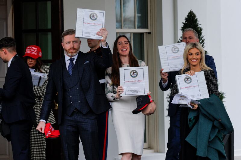 From left to right, Rogan “DC Draino” O‘Handley, Chaya Raichik, and Liz Wheeler show off a binder labeled as phase one of the “Epstein Files.” The binders did not contain new information, it was revealed after they met with President Donald Trump.