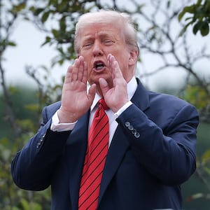 WASHINGTON, DC - AUGUST 05: U.S. President Donald Trump shouts answers to questions from reporters as he tours the roof of the West Wing of the White House.