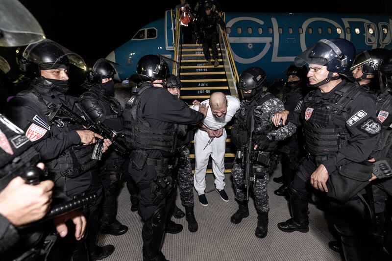 Salvadoran police officers take an alleged member of the TdA gang to prison after he was deported by the U.S. government.