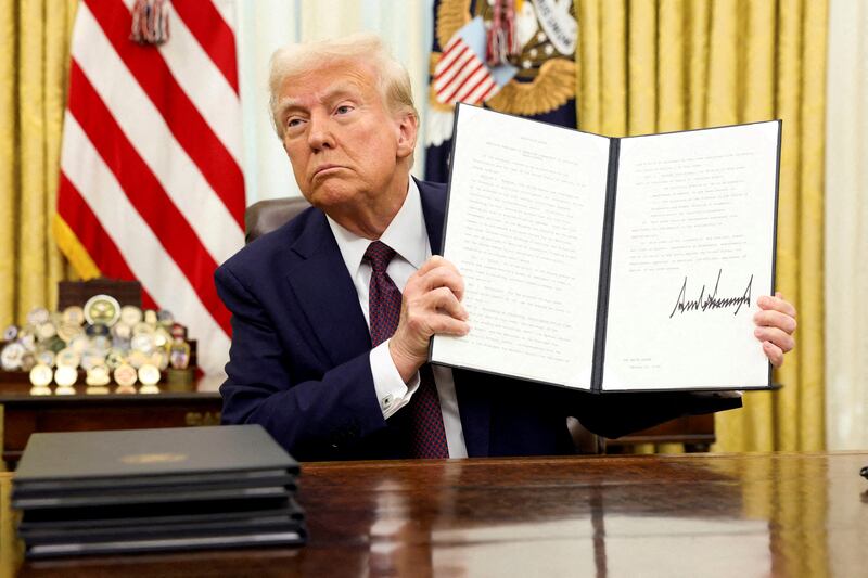President Donald Trump holds a signed executive order in the White House Oval Office in Washington, D.C. on January 23, 2025.