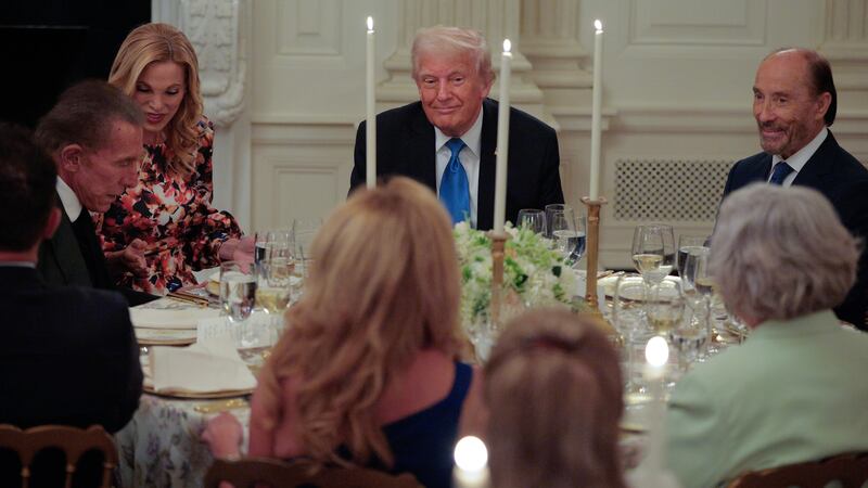 WASHINGTON, DC - MAY 19: U.S. President Donald Trump (C) sits with (L-R) casino and hotel magnate Steve Wynn, his wife Andrea Hissom, singer Lee Greenwood and others while hosting members of the board of the Kennedy Center in the State Dining Room at the White House on May 19, 2025 in Washington, DC. Trump installed himself as chairman of the John F. Kennedy Center for the Performing Arts after 18 board members who had been appointed by former President Joe Biden and replaced them with loyalists. (Photo by Chip Somodevilla/Getty Images)