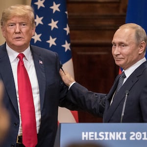 President Donald Trump (L) and Russian President Vladimir Putin shake hands during a joint press conference after their summit on July 16, 2018 in Helsinki, Finland.