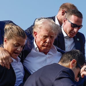 BUTLER, PENNSYLVANIA - JULY 13: Republican presidential candidate former President Donald Trump is rushed offstage by U.S. Secret Service agents after being grazed by a bullet during a rally on July 13, 2024 in Butler, Pennsylvania. Butler County district attorney Richard Goldinger said the shooter is dead after injuring former U.S. President Donald Trump, killing one audience member and injuring another in the shooting. (Photo by Anna Moneymaker/Getty Images)