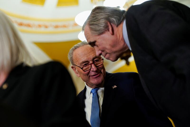 Chuck Schumer (left) speaks with U.S. Sen. Jeff Merkley (right) in February. The allies have become rivals this week regarding a stopgap funding bill proposed by Republicans.