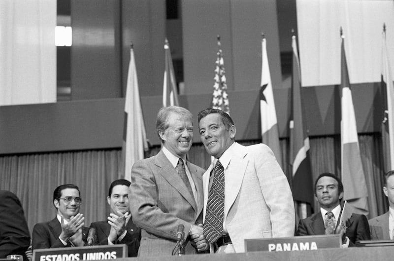President Jimmy Carter and General Omar Torrijos, Panama's military ruler, shake hands after they signed the ratified Panama Canal Treaties.