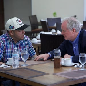 Kilmar Abrego Garcia and Senator Chris Van Hollen sit at a table in a restaurant.