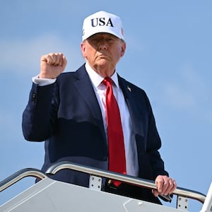 President Donald Trump pumps his fist while boarding Air Force One at Joint Base Andrews in Maryland