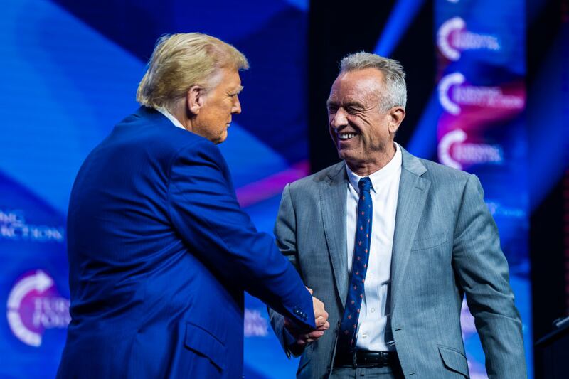 Robert F. Kennedy Jr. speaks with Donald Trump at a 2024 campaign rally in Georgia.