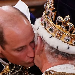 TOPSHOT - Britain's Prince William, Prince of Wales kisses his father, Britain's King Charles III, wearing St Edward's Crown, during the King's Coronation Ceremony inside Westminster Abbey in central London on May 6, 2023. The set-piece coronation is the first in Britain in 70 years, and only the second in history to be televised. Charles will be the 40th reigning monarch to be crowned at the central London church since King William I in 1066. Outside the UK, he is also king of 14 other Commonwealth countries, including Australia, Canada and New Zealand. Camilla, his second wife, will be crowned queen alongside him and be known as Queen Camilla after the ceremony. (Photo by Yui Mok / POOL / AFP) (Photo by YUI MOK/POOL/AFP via Getty Images)