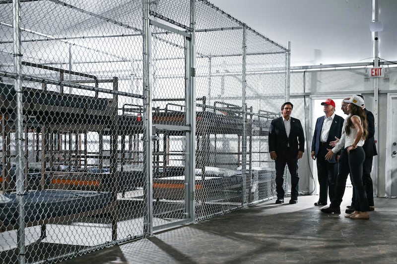 President Donald Trump (2L), Florida Governor Ron DeSantis (L), and Secretary of Homeland Security Kristi Noem (R) tour a migrant detention center, dubbed "Alligator Alcatraz," located at the site of the Dade-Collier Training and Transition Airport in Ochopee, Florida on July 1, 2025.
