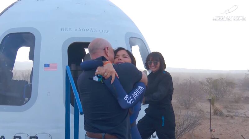 Sanchez and Bezos embrace after landing.