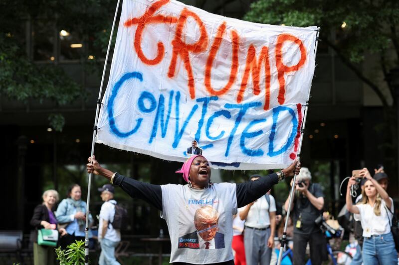 A demonstrator holds a placard outside Manhattan criminal court following the verdict in former U.S. President Donald Trump's criminal trial over charges that he falsified business records to conceal money paid to silence porn star Stormy Daniels in 2016, in New York City, U.S. May 30, 2024. REUTERS/Mike Segar