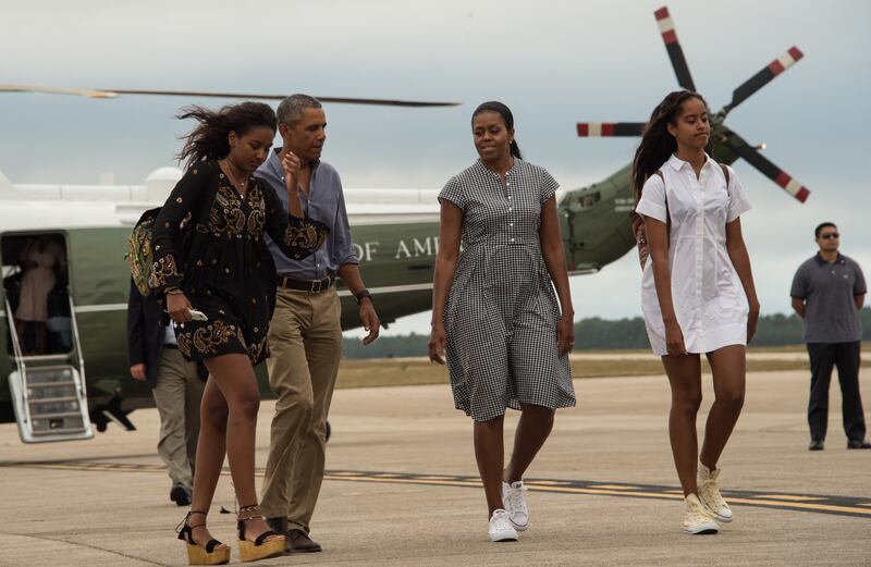 US President Barack Obama, First Lady Michelle Obama and daughters Malia and Sasha walk to board Air Force One at Cape Cod Air Force Station in Massachusetts on August 21, 2016 as they depart for Washington after a two-week holiday at nearby Martha's Vineyard.