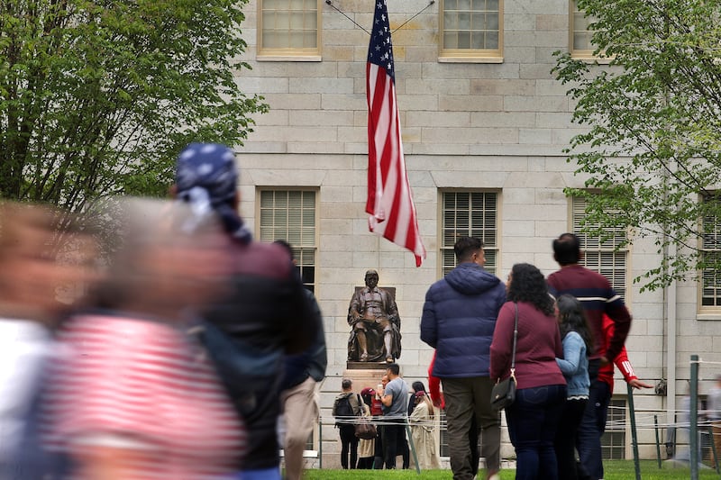 A Tour groups walk past the statue of John Harvard in Harvard Yard on May 2, 2025.