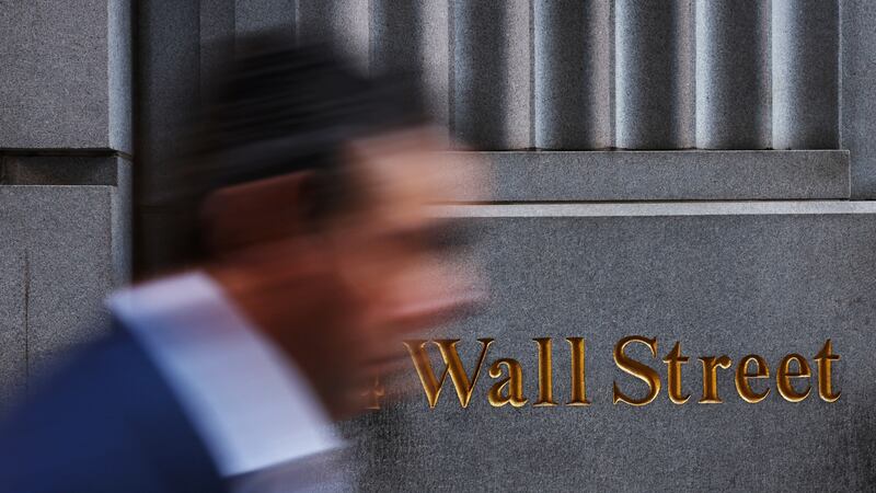 A man walks past a Wall Street marking outside the New York Stock Exchange (NYSE) building on Tuesday following Monday’s broad sell off in New York City, U.S., March 11, 2025. REUTERS/Shannon Stapleton