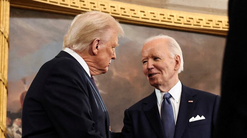 Donald Trump and Joe Biden shake hands.