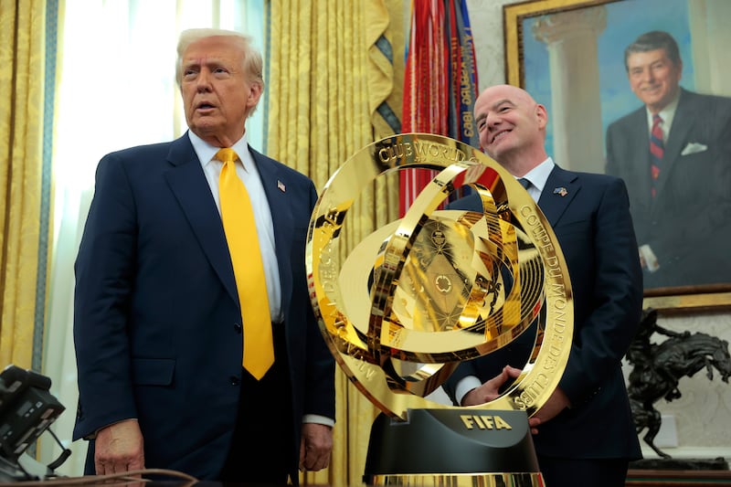 Donald Trump speaks alongside President of Fédération Internationale de Football Association (FIFA) Gianni Infantino after unveiling the 2025 Club World Cup trophy in the Oval Office.